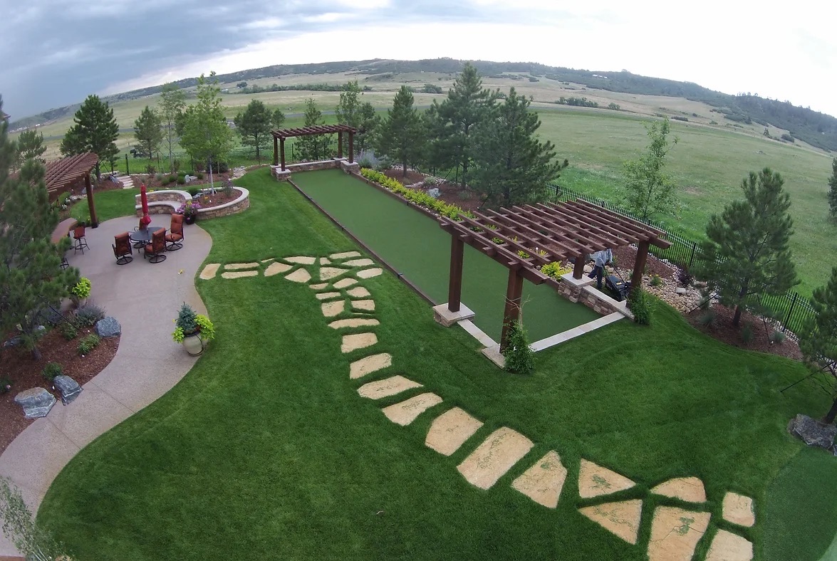 Backyard bocce court with pergolas and stepping stones