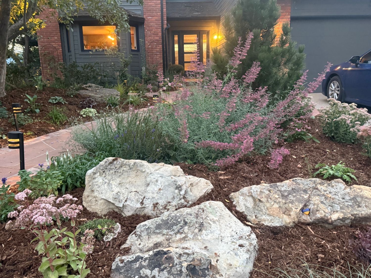 Boulders and flowering perennials in a front-yard bed
