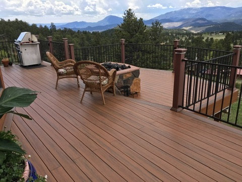 Composite deck with a fire table, wicker chairs and mountain views