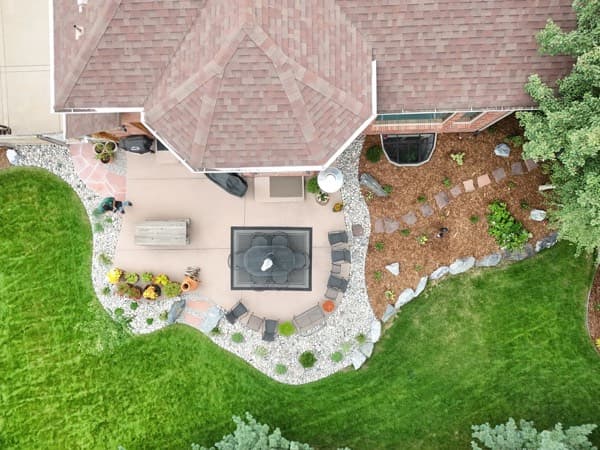 Aerial view of a curved dining patio surrounded by lawn and planting beds