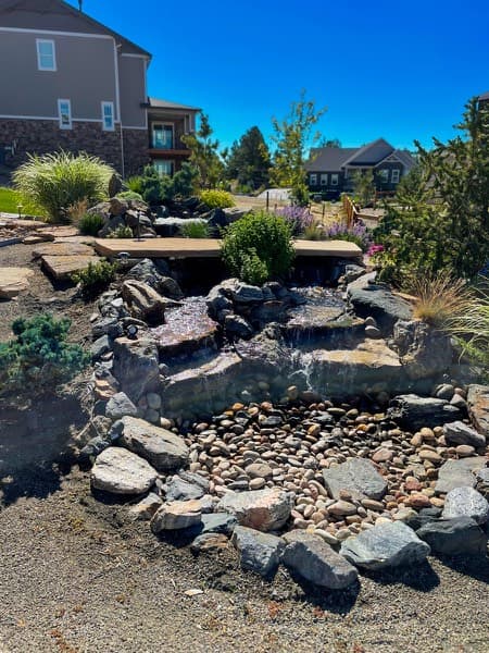 Rock stream with waterfalls and a stone slab bridge