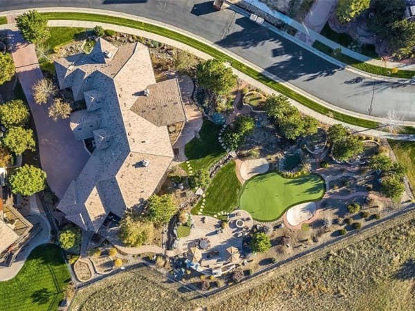 Aerial view of an estate landscape with a putting green, patios and planting beds